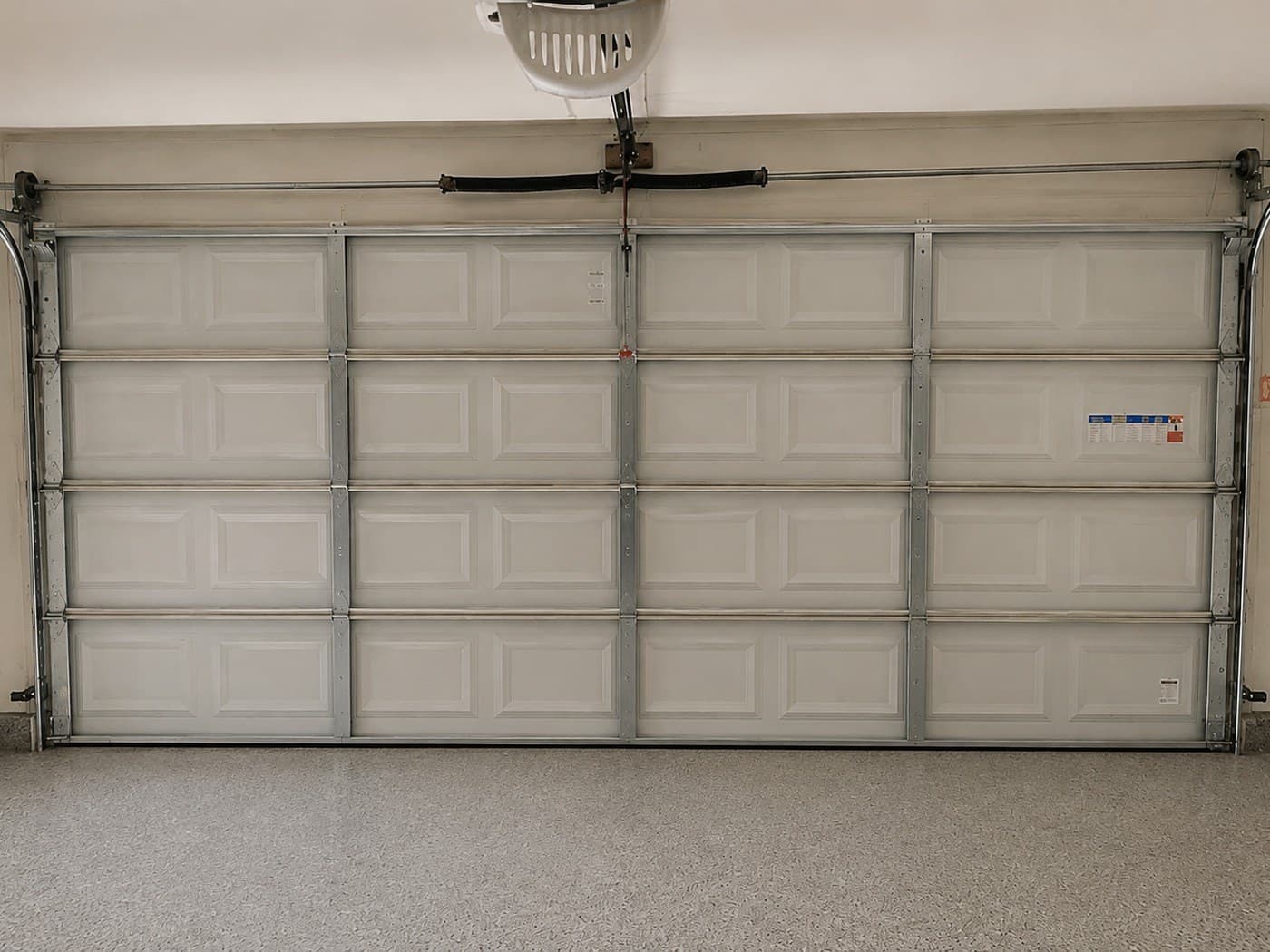 Garage door off track repair in Royal Palm Beach — the same sectional door back on its rollers, balanced and closing evenly after the repair